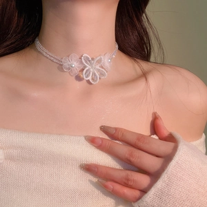 Detailed close-up of a white crystal beaded flower choker necklace worn on neck