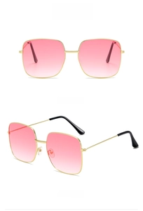 Detail view of retro gold frame sunglasses with pink gradient lenses and metal side temples