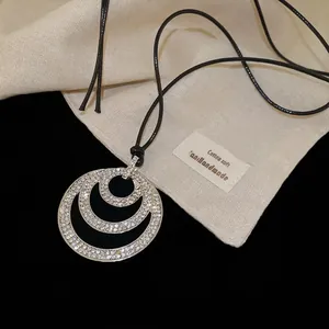 Three-layer circular crystal pendant necklace with black leather cord and sparkling zircons