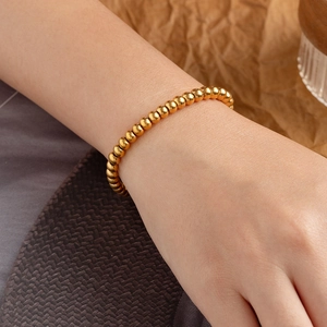 Bracciale a sfere in acciaio inossidabile placcato oro 18K per donna su polso con sfondo caldo