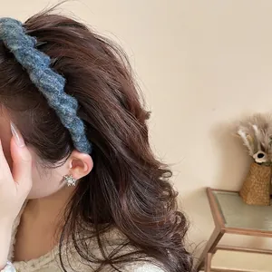 Navy blue tweed knitted headband and silver snowflake earrings on a female model