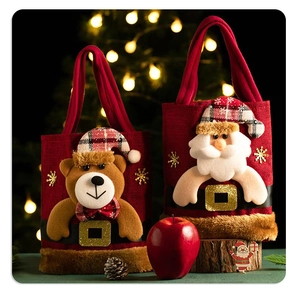 Detailed view of red burlap Christmas gift bags featuring 3D Santa and bear designs