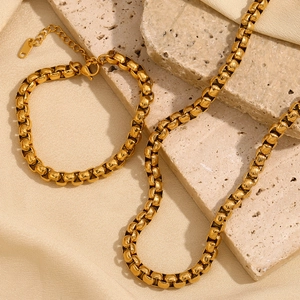 Detail of 18K gold plated square snake chain necklace and bracelet on stone