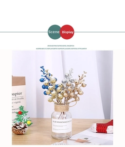 Blue gold and silver glitter berry stems in a glass vase for Christmas table decor