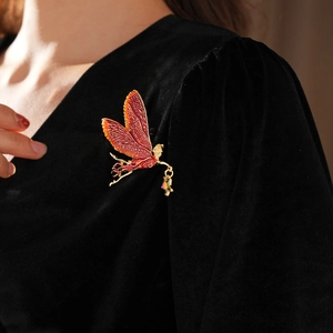 Detail of vintage enamel fairy brooch with star pendant on a black velvet suit
