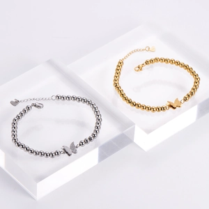 Detail of double-layer beaded butterfly bracelets in gold and silver plating