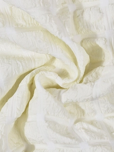 Macro shot of cream white waffle texture fabric with three-dimensional woven pattern
