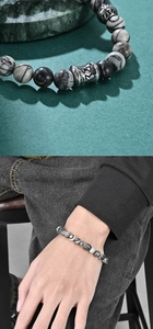Macro detail of Buddhist mantra beads and volcanic stone bracelet on a man's wrist