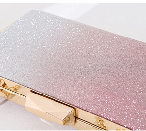 Macro shot of gradient silver-to-pink glitter surface on evening bag with gold clasp