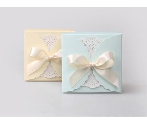 Close-up of pastel blue and beige gift boxes with lace paper and ribbon bows