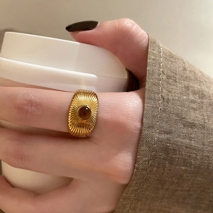 Maillard style oval gold ring on hand holding coffee cup, vintage aesthetic jewelry