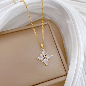 Luxurious gold clover pendant necklace with sparkling diamonds on elegant silk fabric