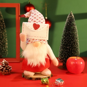 Plush Christmas gnome figurine holding a heart envelope on a festive wooden stand