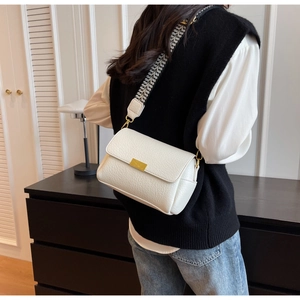 Détail du sac bandoulière blanc en cuir grainé avec sangle tissée et boucle dorée