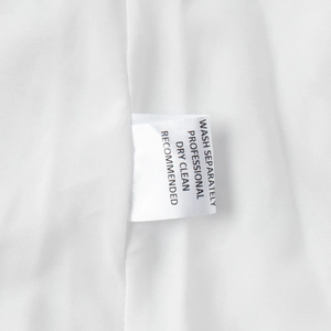 Macro detail of white cotton fabric texture and professional care label with wash instructions