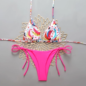 Detail of banana print bikini top and neon pink side-tie bottoms on floral display