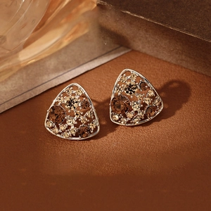 Macro view of vintage silver hollow triangle earrings with champagne crystal pavé setting