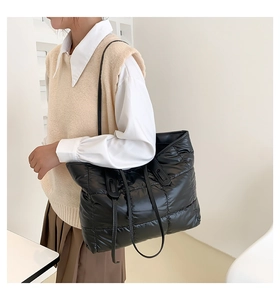 Detail of black quilted puffer tote bag in lightweight nylon with square stitch pattern