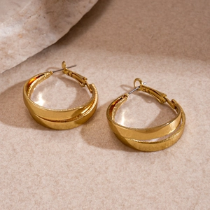 Polished gold double-layer hollow hoop earrings on elegant natural stone background
