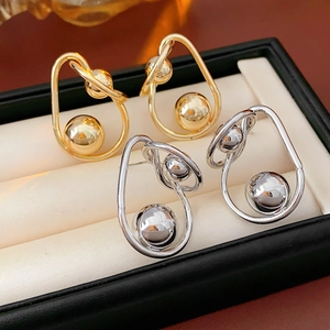 Macro view of gold and silver twisted spherical stud earrings in a jewelry box