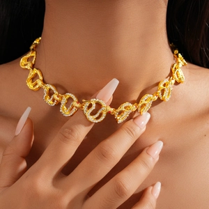 Macro view of gold snake-shaped interlocking chain necklace with sparkling rhinestones