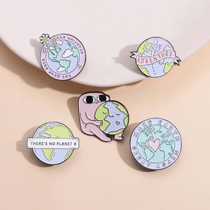 Détails de cinq pin's émaillés écolo avec slogans Jour de la Terre sur fond beige