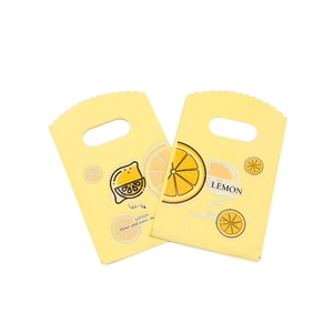 Close-up of small yellow plastic gift bags with lemon prints and handle cutouts
