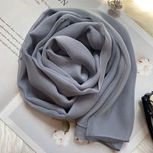 Macro detail of elegant light blue silk scarf folded into a rose shape on a soft backdrop