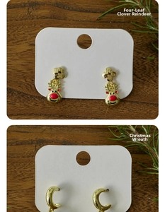 Detail of Christmas stud earrings featuring reindeer and festive wreath charms