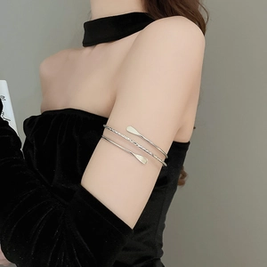 Detail view of a minimalist silver multi-layered wrap armlet on model's upper arm