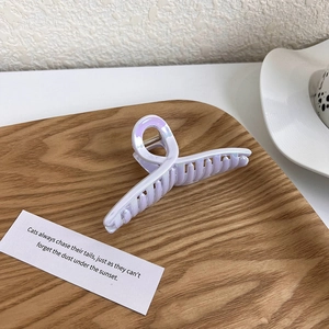 Detail of lilac purple hair claw clip with pearlescent finish on a wooden tray