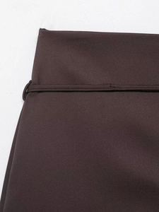 Detailed view of dark brown skirt waistband showing high-quality stitching and fabric texture