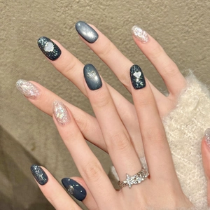 Handmade black cat-eye press-on nails with 3D hearts and glitter stars for a chic style