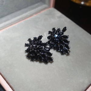 Macro view of vintage floral stud earrings featuring black marquise-cut crystals