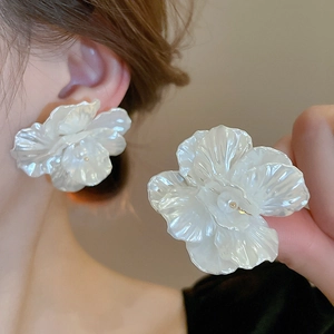 Elegant large ivory petal flower earrings with pearl center in a stylish summer look