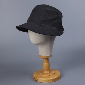 Détail du chapeau bob en nylon noir avec coutures renforcées sur le bord sur un mannequin
