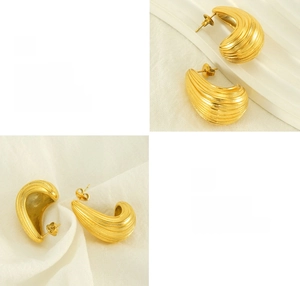 Macro detail of curved gold plated stainless steel earrings with textured ripple design