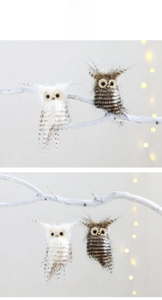 Detail of soft plush owl ornaments with realistic feathers on white tree branches
