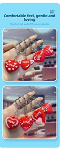 Detail of red heart PVC keychains featuring angel wings and romantic LOVE slogans