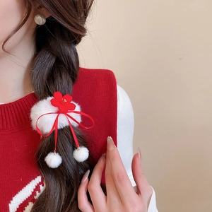 Close-up of red floral plush hair scrunchies with white pom-poms on a braided ponytail