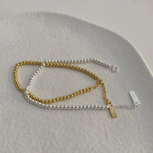 Macro view of minimalist S925 sterling silver beaded bracelets in gold and silver finish
