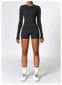 Detail of black long-sleeved yoga top and high-waisted fitness shorts set