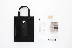 Close-up of black mesh beach bag with personal care items like shampoo and soap