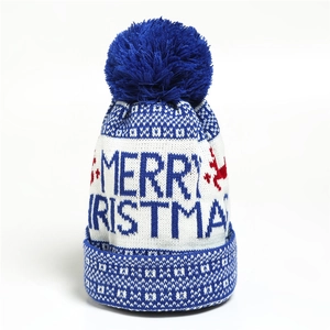 Detailed close-up of knitted Christmas hat with blue pom-pom and merry text embroidery