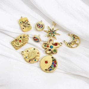 Golden celestial pendants with colorful crystals on white silk background