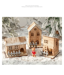 Detail view of illuminated wooden Christmas houses with a small bear ornament in snow