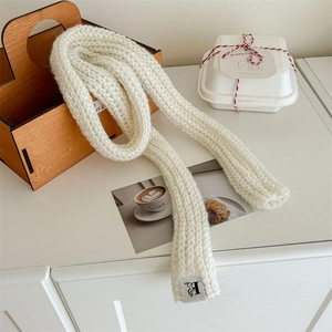 Chic solid white knit wool scarf for women styled on a wooden basket and gift box