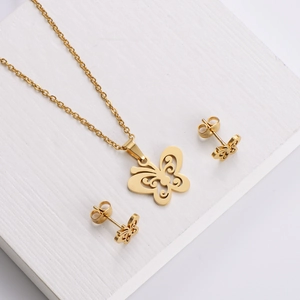 Polished gold butterfly jewelry set with necklace and earrings on white pedestal