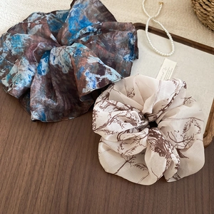 Close-up of vintage oversized organza scrunchies on a wooden tray with pearls
