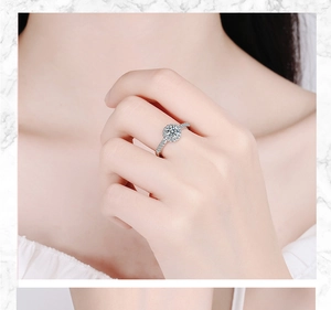 Close-up of a silver wide band ring featuring a round-cut main stone and pave-set diamonds